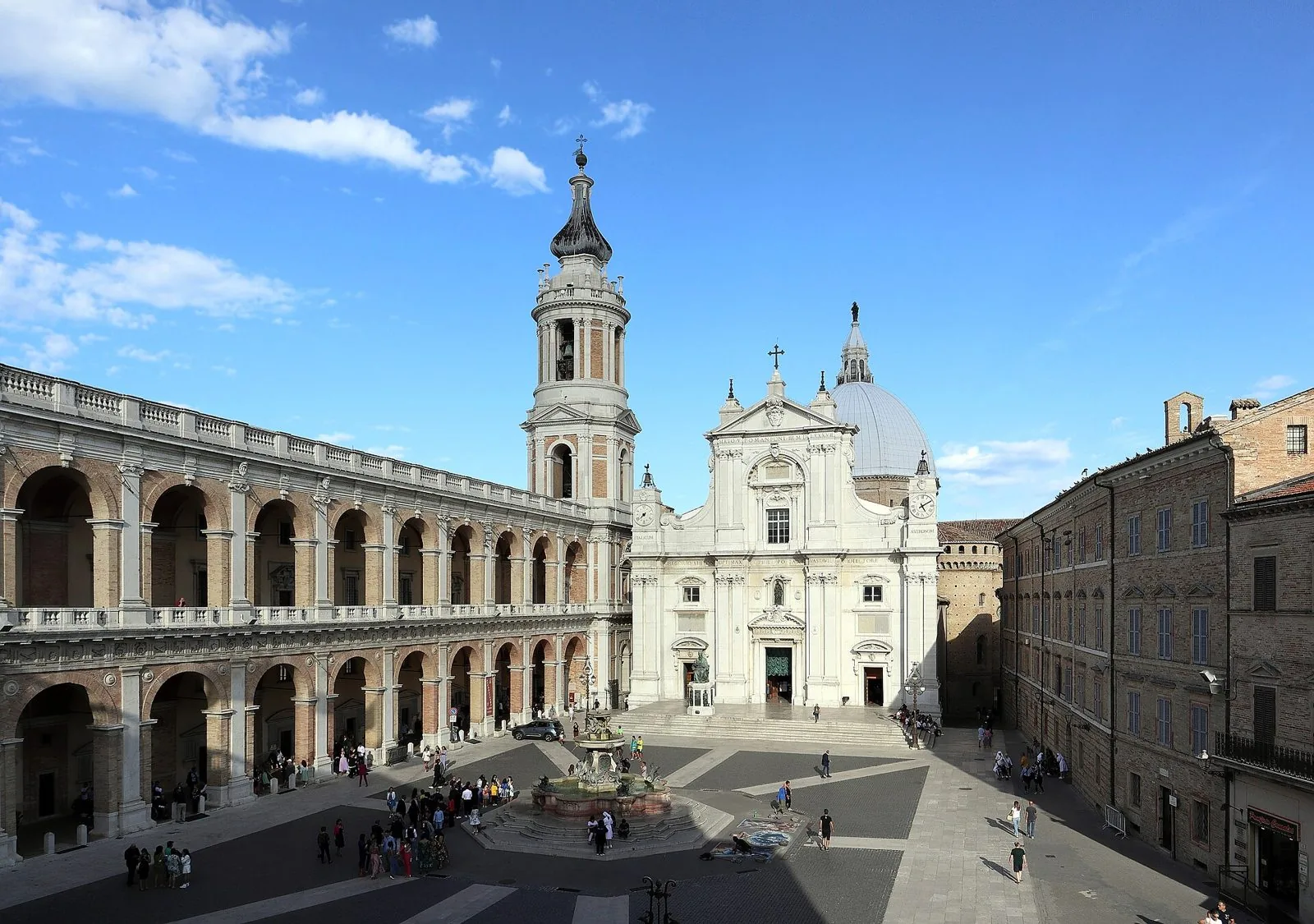 Facciata bianca della Basilica della Santa Casa di Loreto con il campanile, la cupola e il porticato del Palazzo Apostolico in Piazza della Madonna